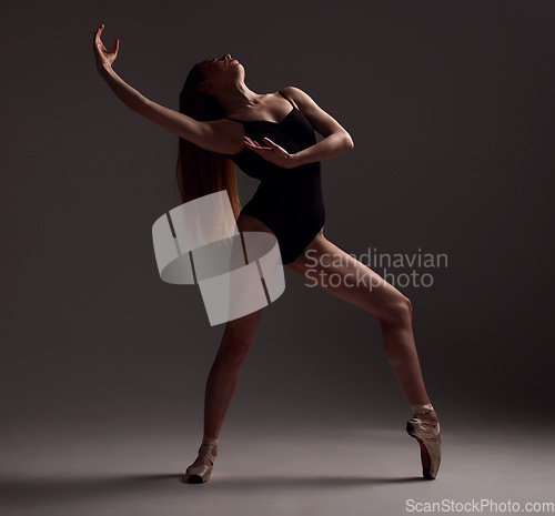 Image of Ballet, woman and dancer with pose, exercise and training for performance on a dark studio background. Female performer, ballerina and artist with technique, practice routine for show and elegant art