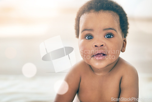 Image of Portrait, baby and mockup with an african child sitting on a bed in the bedroom of a home for growth or development. Children, face and an adorable black kid looking curious in a house with flare