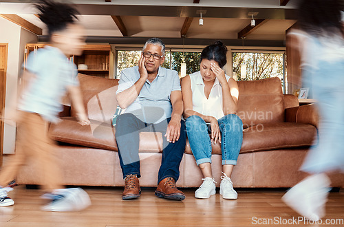 Image of Kids running, stress and grandparents on couch tired, chaos in living room and frustrated babysitting burnout. Hyperactive children with energy, playing in home with grandma and grandpa with headache