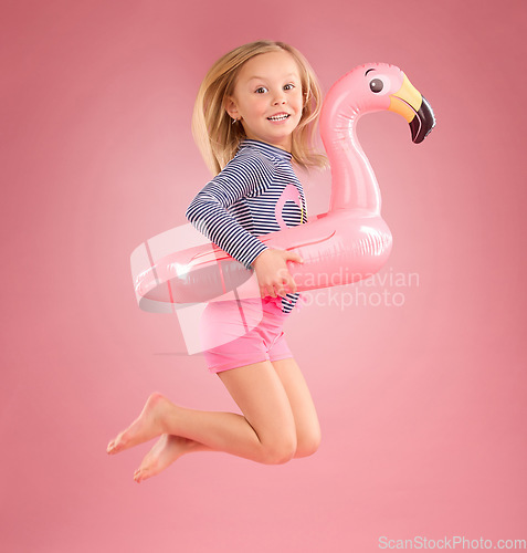 Image of Jump, smile and portrait of girl and pool float for swimming, summer break or happiness. Youth, funny and inflatable with child and flamingo ring for cute, happy or beach holiday on pink background