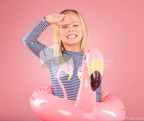 Image of Safety, smile and portrait of girl and pool float for swimming, summer break or happiness. Youth, funny and inflatable with child and flamingo ring for pool, smile or beach holiday on pink background