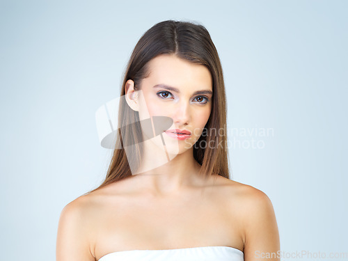 Image of Beauty, skincare and serious with portrait of woman for cosmetics, self care and glow. Natural, satisfaction and makeup with cute girl model for confident, glow and attractive on blue background