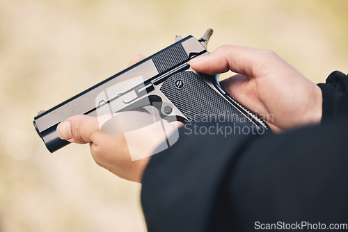 Image of Weapon, pistol and hands with gun outdoor for police, military and safety training at firing range. Security, danger and person holding metal firearm for criminal protection, shooting and fight crime