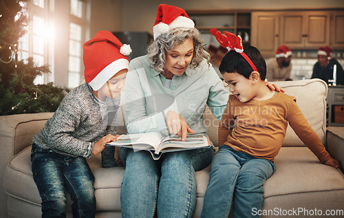 Image of Christmas, photo album or children with a senior woman and kids looking at photographs during festive season. Family, love or celebration with a grandmother and grandchildren holding a picture book