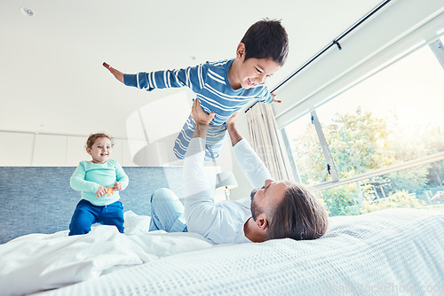 Image of Love, father and kid in air, bed and quality time on break, happiness or bonding together. Family, dad or lifting boy in bedroom, cheerful or playing with joy, game or freedom with affection or smile