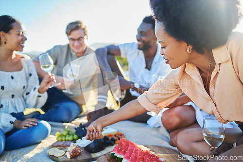 Image of Friends, travel and picnic with food and outdoor in nature, fruit and cheese for nutrition and adventure in park. Wine, sun and summer holiday with social group, diversity and young people together.