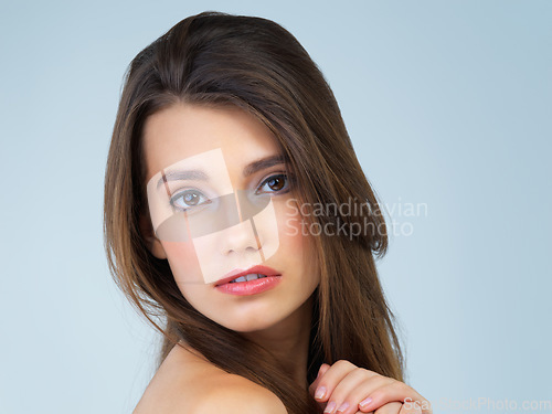 Image of Hair, serious and portrait of woman with makeup on blue background for wellness, skincare and facial treatment. Salon aesthetic, dermatology and face of girl with cosmetics, beauty and confidence