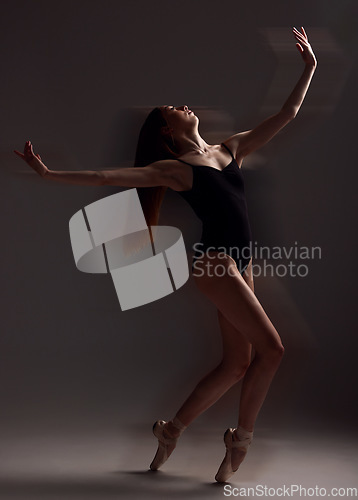 Image of Art, dance and woman in the dark for ballet isolated on a black background in a studio. Creative, elegant and contemporary dancer dancing for a theater performance, rehearsal or ballerina movement