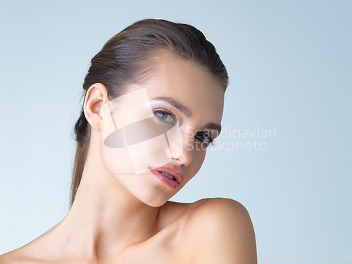 Image of Makeup, portrait and woman in studio for skincare, wellness or cosmetic on blue background. Face, beauty and girl model with luxury, dermatology or product satisfaction or skin routine while isolated