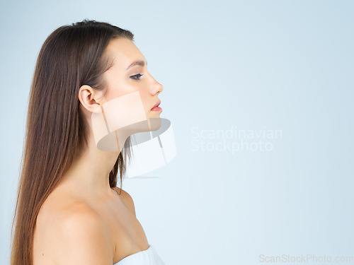 Image of Woman, profile and mockup with makeup, cosmetics and natural beauty aesthetic in a studio. Isolated, blue background and young female model with mock up for advertisement and luxury branding