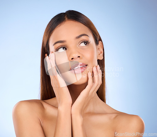 Image of Woman, face and thinking in beauty skincare cosmetics or self love and care against blue studio background. Happy female wondering or touching perfect skin in satisfaction for facial or spa treatment