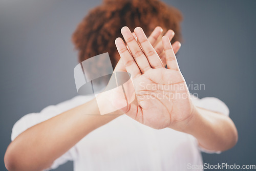 Image of Closeup, hands and woman in studio for stop, warning or domestic violence symbol on grey background. Zoom, justice and hand of girl in protest, caution and protection, scared and abuse awareness