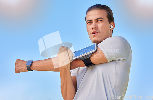 Image of Fitness, health and man stretching arm for cardio exercise running, marathon training or body healthcare goals. Sports, blue sky and natural athlete person warm up for outdoor performance workout.