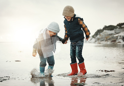 Image of Beach, boots and children in water together, holding hands and playing in waves with smile. Fun, holiday and brothers, happy boys on ocean vacation at sunset, jumping and splash on evening sea walk.