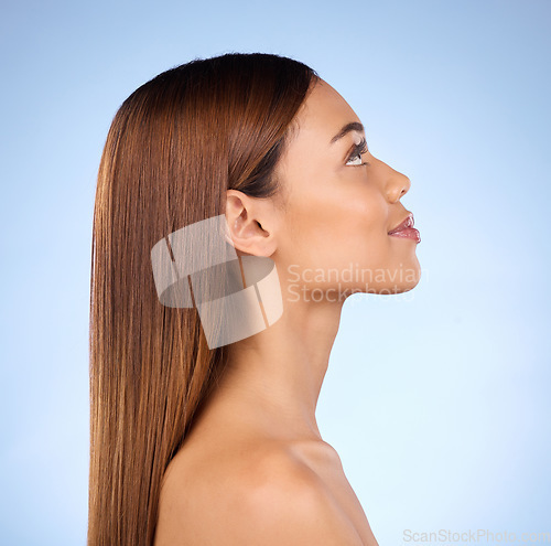 Image of Face, hair care and beauty profile with woman, keratin treatment with shine on blue background. Skincare, natural cosmetics and mockup, facial and hairstyle, female with smile in studio and skin glow