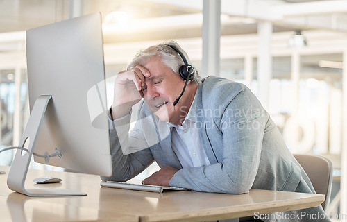 Image of Call center, customer support and headache with a consultant man suffering from pain while working in the office. Crm, service and burnout with a senior male telemarketing working feeling stress