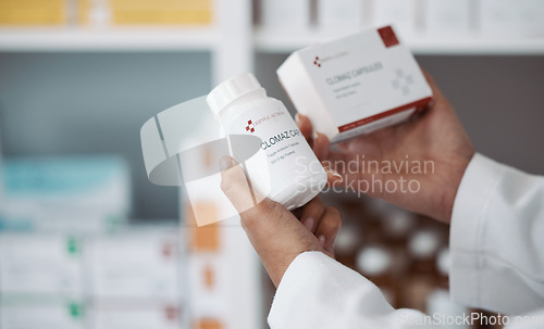 Image of Hands, medicine or healthcare with a man in a pharmacy holding a box and container of antibiotics. Medical, stock and retail with a male pharmacist at work in a clinic, hospital or drugstore