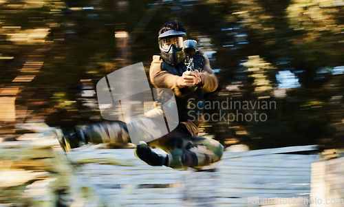 Image of Action, paintball and man shooting and jumping on battlefield with a gun in a game, match or training. Shooter, blur motion and male with strategy in military aim and shoot target outdoors