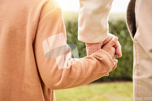 Image of Kid, park and holding hands with parents on vacation, adventure walk or freedom in nature together. Young child child, outdoor happiness or holiday for helping hand, support and walking in sunshine