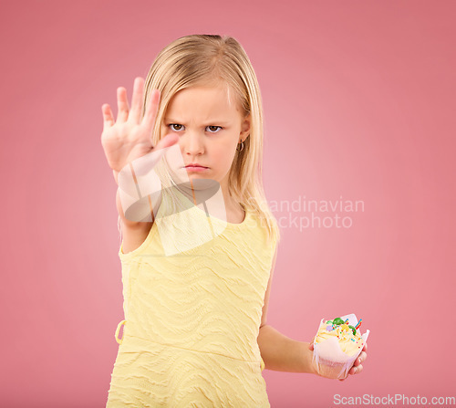 Image of Stop, angry and child portrait with a no hand gesture and cupcake showing a sharing problem. Conflict, frustrated and serious little girl with a birthday dessert in isolated pink background in studio