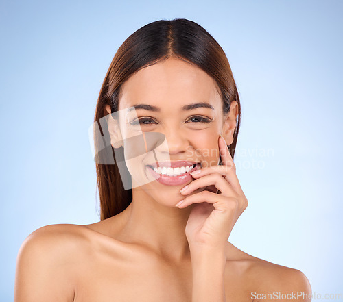 Image of Beauty, portrait and woman with smile, dermatology and treatment against a blue studio background. Face, female and lady with joy, morning routine and skincare for grooming, clear and smooth skin