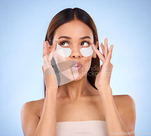 Image of Beauty, woman and face with eye patch for skincare dermatology cosmetics in studio. Female model person on a blue background for self care, facial glow and healthy or clean skin with spa results