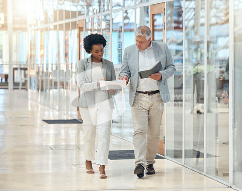 Image of Teamwork, man and black woman in office, walking and discussion for report, schedule and planning. Employees, coworkers and consultants with documents, notebook and check information in workplace