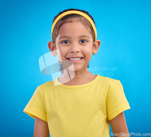 Image of Happy, smile and portrait of girl in studio for natural, youth and confident isolated on blue background. Happiness, break and positive with face of young child for cute, adorable and trendy style