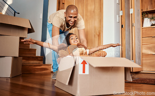 Image of New home, father and pushing girl in box, having fun and bonding after moving in house. Real estate, family property and child with teddy bear, boxes and happy dad playing to celebrate relocation.