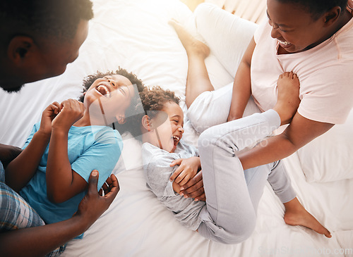 Image of Tickle, funny and relax with black family in bedroom for bonding, playful and affectionate. Laugh, happiness and crazy with parents playing with children at home for wake up, morning and silly