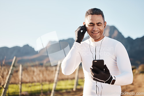 Image of 5g, earphones and nature, happy man and phone at rest stop in countryside looking at location online with music. Mobile streaming, fitness app and smartphone, cyclist on internet search with smile.