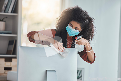 Image of Covid, business and a black woman cleaning her computer in the office for health, safety or control. Compliance, bacteria and regulations with a female employee wiping her desktop pc for disinfection