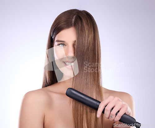 Image of Hair straightener, face portrait and beauty of woman in studio isolated on a gray background. Haircare, happy and female model with flat iron product for salon treatment, balayage and hairstyle.