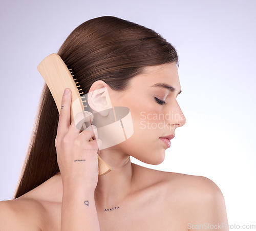 Image of Hair care, beauty and face of woman with brush in studio isolated on a gray background. Eyes closed, eco friendly and female model with sustainable wooden hairbrush for salon treatment or hairstyle.