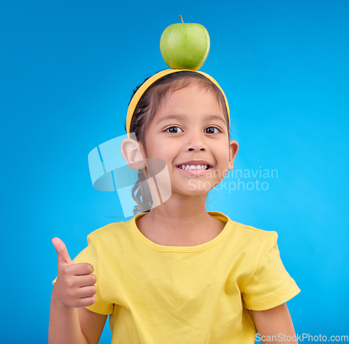 Image of Happy, portrait and a young girl with a thumbs up isolated on a blue background in a studio. Review, success and face a child with a hand gesture for satisfaction, emoji and agreement on a backdrop