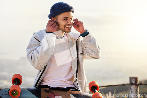 Image of Skateboarder, earphones and man listening to music, audio or podcast online and relax after skating outdoors. Skater, skateboard and person streaming to mobile radio and texting on social media