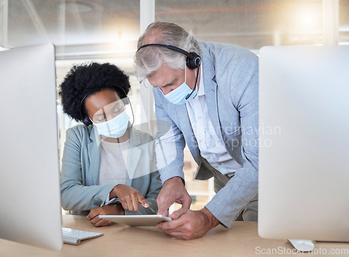 Image of Covid, crm and employees with tablet, mask and senior man helping black woman at call center help desk. Compliance, consulting and opinion, crm data for medical advisory agency with coaching support.