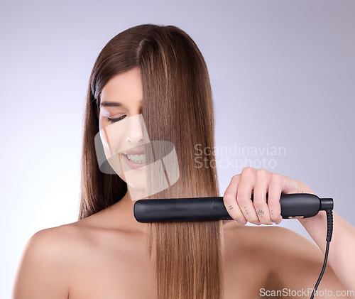 Image of Hair straightener, face and beauty of woman in studio isolated on a gray background. Eyes closed, haircare and happy female model with flat iron product for salon treatment, balayage and hairstyle.