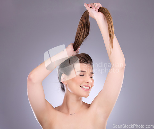 Image of Eyes closed, beauty and hair care of a woman in studio isolated on a gray background. Cosmetics, growth or happy female model with salon treatment for healthy keratin, balayage or long hairstyle pull