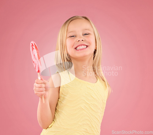 Image of Candy, smile and lollipop with portrait of girl in studio for sugar, party and carnival food isolated on pink background. Cute, positive and youth with child and eating snack for playful and treats