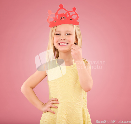 Image of Girl, child and smile portrait with a crown in studio on a pink background with smile and prop. Female princess kid model with happiness, creativity and royal icon in hand isolated on color and space