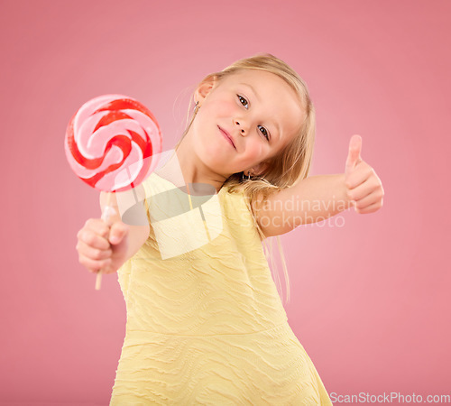 Image of Candy, thumbs up and lollipop with portrait of girl in studio for sugar, party and carnival food isolated on pink background. Cute, positive and youth with child or eating snack for playful and treat