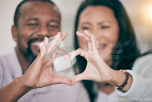 Image of Hands, love and heart with a couple in their home to relax together in the living room closeup. Hand gesture, emoji or romance with a senior man and woman bonding while sitting in their house