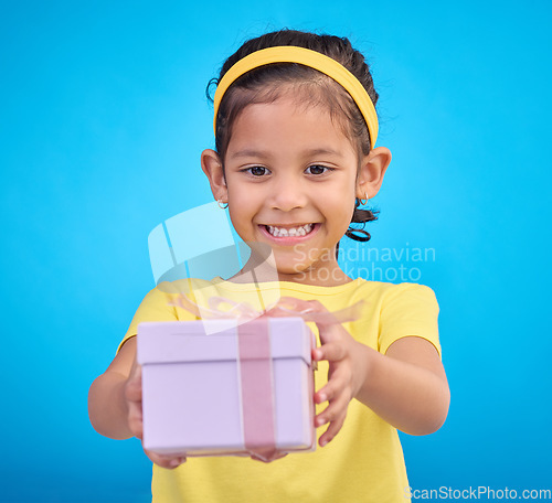 Image of Box, present and girl with smile, excited and cheerful against a blue studio background. Female child, kid and young person with gift, package and happiness with joy, excitement and product promotion