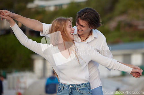 Image of Freedom, happy and laughing couple at the beach for a date, honeymoon and bonding in Bali. Smile, flying and playful man and woman with care, love and affection at the sea for happiness together