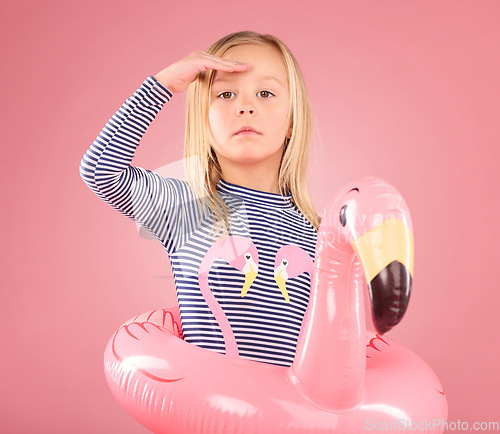 Image of Safety, search and portrait of girl and pool float for swimming, summer break or cute. Youth, swimsuit and inflatable with child and flamingo ring for playful, beach and holiday on pink background