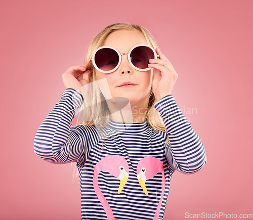 Image of Studio, portrait of small girl with sunglasses and fun clothes on vacation isolated on pink background. Summer, holiday and cool fashion clothing, happy child in Australia for travel and adventure