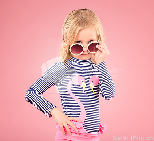 Image of Holiday, portrait of child in studio with sunglasses and fun clothes isolated on pink background. Summer, vacation and fashion for children, girl in Australia on travel in serious face and beachwear