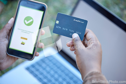 Image of Credit card, phone banking app and approval check on a mobile website payment with laptop mockup. Online shopping, ecommerce and 5g connectivity of a customer doing a internet sale outdoor on grass