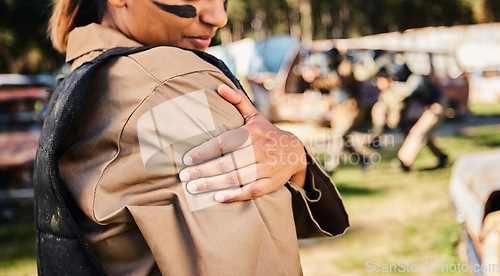 Image of Hands, soldier and arm injury in paintball sport, running or military training from intense battle or war on grass field. Hand of sports army woman holding painful shoulder ache, accident or wound